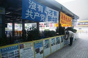 '吴创,十三年来每天必做的事,将一个一个展板卸下,整整齐齐挂上;并将棉绳一线一线串起真相展板并绑牢'