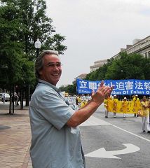 观众Robert一直对着游行队伍鼓掌表示支持,当看到白衣方阵的学员拿着被迫害致死的学员遗像走过来时,Robert哭了。