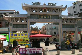 '金门学员在菜市场代天府前揭露中共迫害法轮功,并呼吁帮助营救被中共非法关押的台湾法轮功学员钟鼎邦。'
