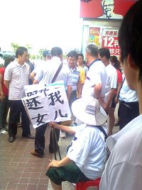 '被便衣警察围住的出言相助的路人(戴着眼镜、穿蓝白条相间T恤衫)'