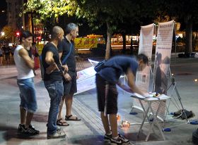 夜深了,游客仍在阅读法轮功真相,签名反迫害