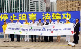 '首尔广场反迫害联合集会上,各界代表在反迫害征签大横幅上按手印并签名谴责中共对法轮功的迫害'