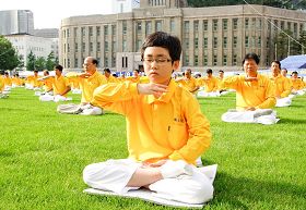'法轮功缓慢圆的五套功法,简单易学适合各年龄层的人学炼。图为首尔广场前绿色的草坪上法轮功学员炼功身影。'