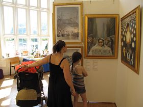 莎拉带着自己的两个孩子来看画展,她似乎完全沉浸在画作里了