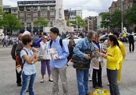 达姆广场上,路人专注听法轮功学员讲真相