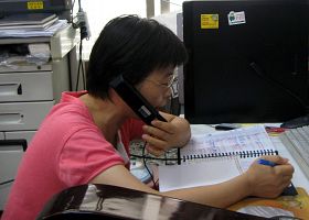 彭淑渼正在给中国大陆同胞拨打电话,讲法轮功真相。