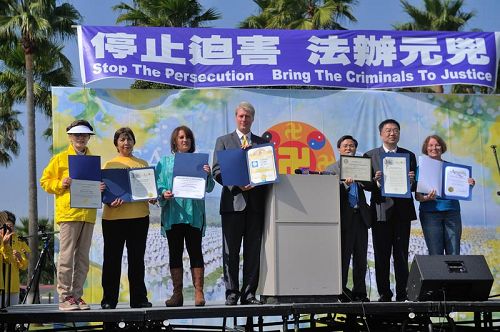'图1:二零一三年十月二十日,二千多名法轮功学员聚集在洛杉矶海滨城市长滩举行集会,揭露中共反人类罪行,多位政要颁发的褒奖。'