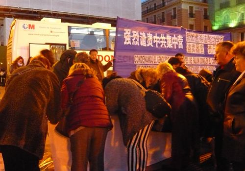 夜幕降临,路灯亮起,前来签名谴责中共迫害的人们仍络绎不绝