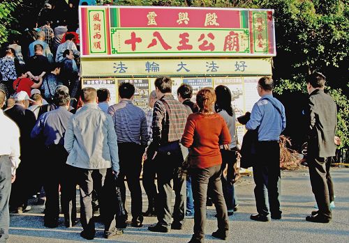 图2:高雄西子湾每天都有很多大陆游客观光,驻足观看法轮功真相展板。