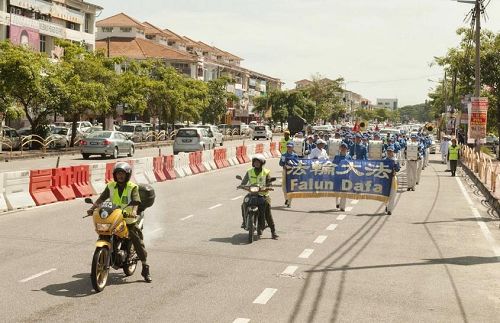 '天国乐团在警方和志愿警卫团(RELA)协助开路下,在槟城北海游行'
