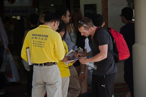 '图:在市中心演示中共活摘场景并征集签名'