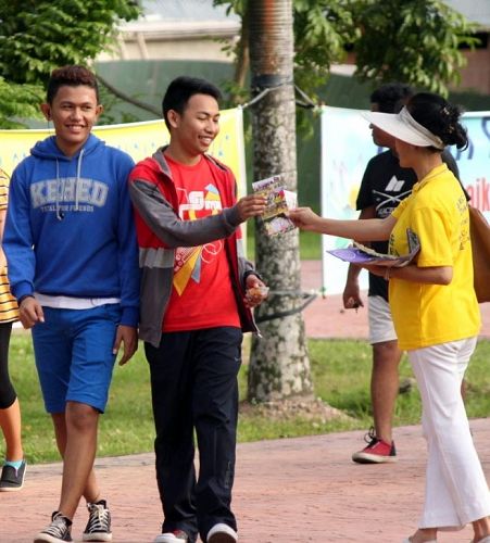 '晨运的民众喜闻法轮大法,开心向学员索取资料。'
