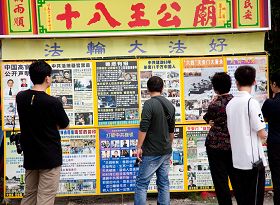 西子湾陆客在法轮功真相展版墙前,仔细阅读,明白真相。