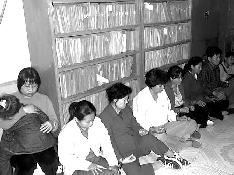 '这是在妙峰山派出所,警察拍的登在中共报纸上诽谤文章中的照片。除了那个带孩子的法轮功学员,我们都被手铐铐在了一起。'