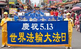 高雄地区法轮大法学员满怀喜悦,在人潮密集中心踩街游行,吸引许多民众观看,拍照留念。