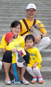 工程师、教师夫妇带着三位年幼的小娃儿,一家五人很开心一起参加庆祝游行活动。