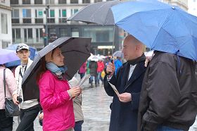 '风雨中人们驻足了解真相,签名反迫害'