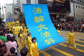 学员手持「法轮大法好」大幡,在九龙市区走过。