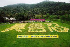 法轮功学员齐聚草坪排出“真、善、忍”的图形,恭敬地双盘合十,齐声高喊“法轮大法好”