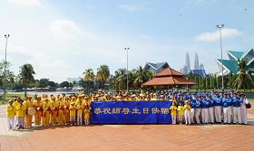 '活动结束前法轮功学员在蒂蒂旺莎湖滨公园广场合影,恭祝师尊生日快乐。'
