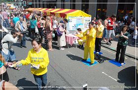 图2:格拉斯哥艺术节中法轮大法的展位,法轮功学员在功法演示和派发传单