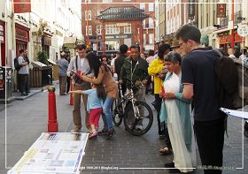 图2:英国法轮功学员在伦敦唐人街演示功法、讲真相并征集支持反迫害的签名,路人纷纷驻足了解真相。