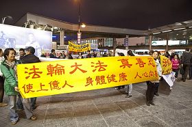 '突破暴徒围攻,法轮功学员打出“真、善、忍”的横幅'