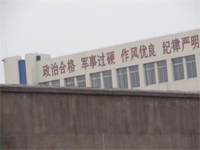'潍坊市看守所(办公楼东楼),东楼上标着“政治合格 军事过硬……”的标语大字,显示看守所施行的是军事化管理、并把“政治”放在第一位、“政治”上向中共表态。'