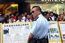 '图2:警方封锁整条街道,阻止涌上街头的香港市民接近法轮功真相点。'