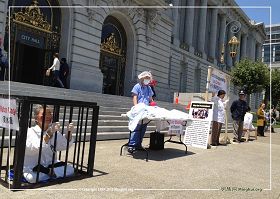 '旧金山法轮功学员在市政府前举办真人演示的“反酷刑展”,揭露迫害,呼吁制止迫害。'