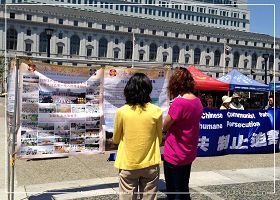 '不少民众观看了真人演示的“反酷刑”展后,与学员攀谈,了解更多法轮功的真相。'