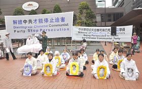 法轮功学员在集会上手持被迫害致死的同修遗像,呼唤正义良知。