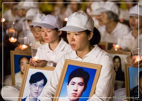 图9:法轮功学员手捧着被迫害致死的中国法轮功学员照片,表情静穆。