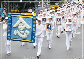 图4:学员穿着净白素服,手捧被迫害致死的大陆法轮功学员照片,圣洁肃穆地行进着
