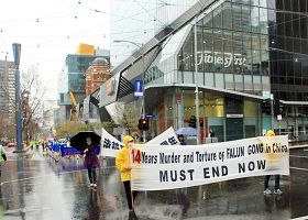 图1、2:反迫害十四周年,墨尔本法轮功学员冒雨游行集会。