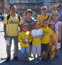 '图3:来自捷克的两位越南裔法轮功学员带着家人和孩子参加了“七二零”法轮功哥本哈根大游行,并在市政厅广场上发放法轮功真相传单'