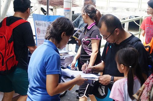 马国吉胆岛村口,当地民众与游客纷纷签名,谴责中共活摘器官暴行。