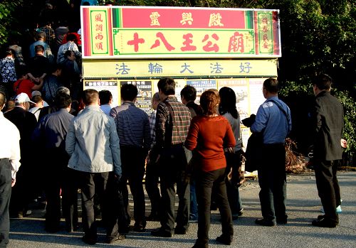 图:大陆游客在台湾西子湾景点了解法轮功真相