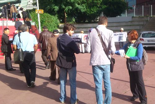 '法轮功学员在第十六届欧洲器官移植大会入口处拉开横幅,揭露中共活摘器官'