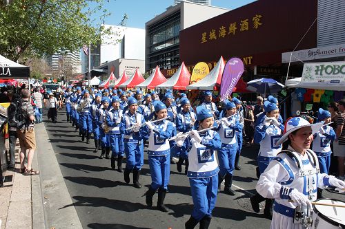 图1-2:身着蓝白色古装,步伐矫健,精神抖擞,阵容整齐的法轮大法“天国乐团”。
