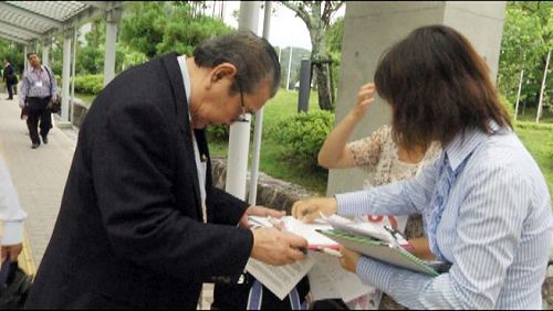 '图:在移植大会入口处征集签名'