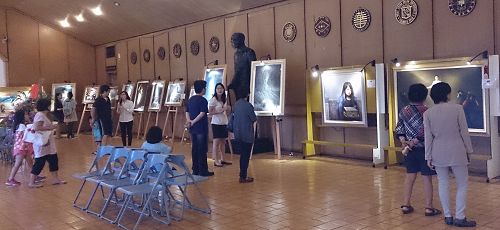 美展会场人们观看画作,并听导览解说