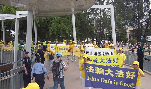 图4:天气炎热,警察给游行中的法轮功学员们送水