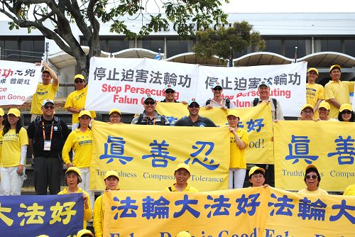 图6:游行结束时,数名警察主动表示要拉法轮功横幅和学员们大合照。