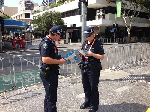 图3:布里斯本二十国集团峰会(G20)峰会期间,澳洲警察在阅读法轮功真相资料。