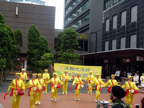 图5:部份腰鼓队的法轮功学员还表演了腰鼓,很多民众鼓掌照相
