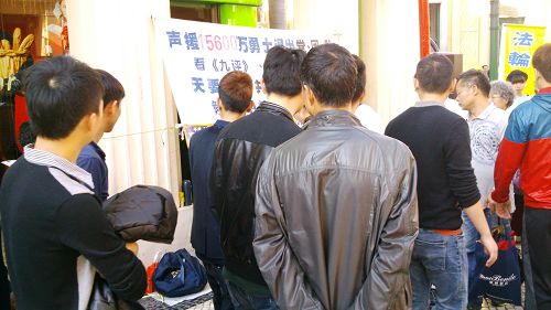 图1-2:新年期间,澳门法轮功学员来到大三巴牌坊的真相点讲真相、劝三退。吸引许多游客驻足观看真相展板。