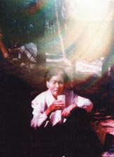 '八十一岁的吴今善老人在民俗村野游时的照片,老人背后有巨大光环。但据一起去的家人讲,那天是阴天,根本见不到太阳。'