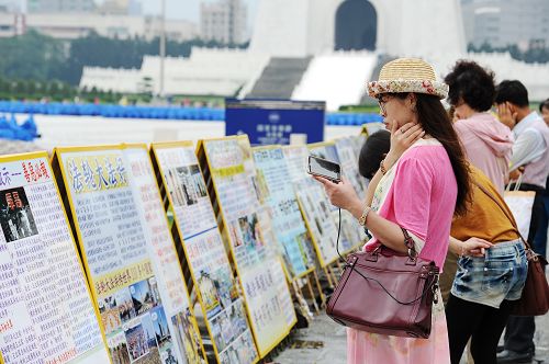 图5-7:一旁的“正法之路图片展”与“真相展板”让民众在观赏排字之余,也有机会深入了解世界各地法轮功学员多年来洪法、讲真相的历程