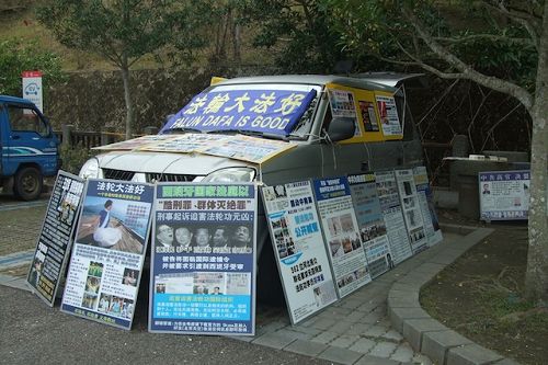 玄光寺停车场上摆满真相展板的车子,后座还有一台电视不断播放真相,常有游客停下脚步仔细观看。